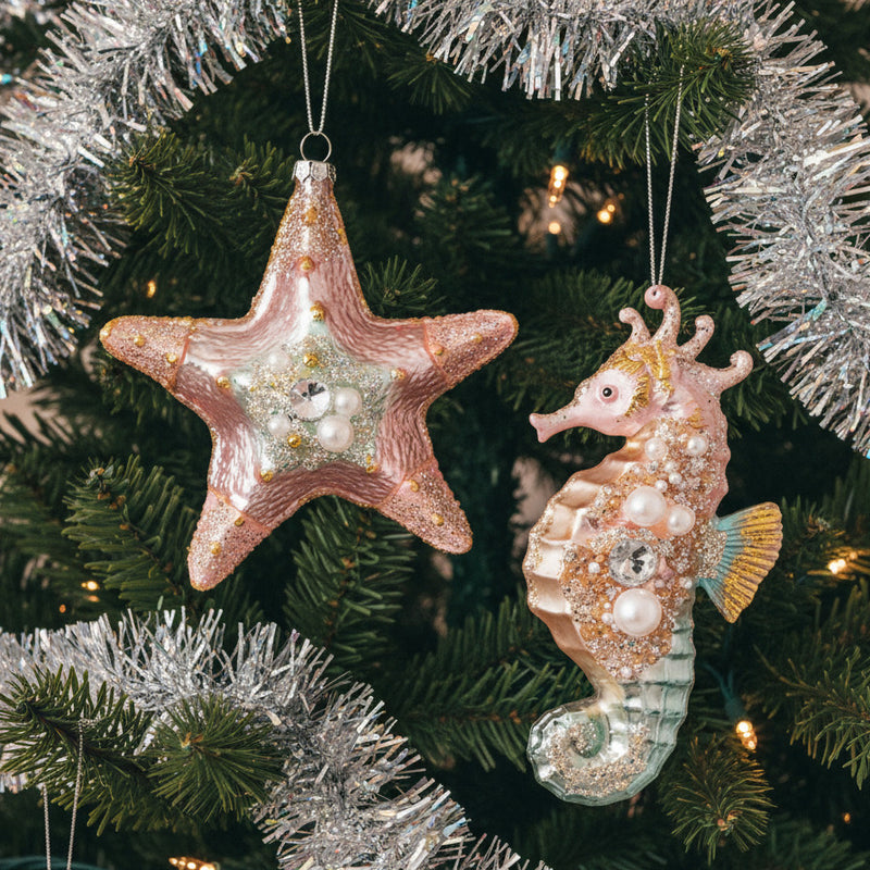 Decorative starfish and seahorse ornaments in lighted Christmas tree