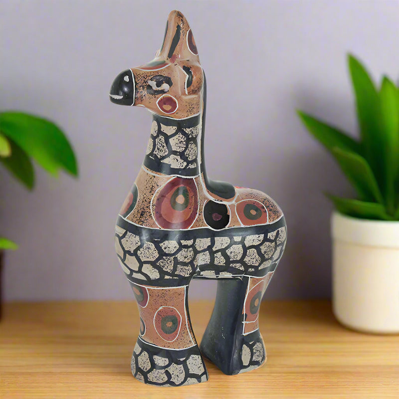 colorful soapstone giraffe figurine on shelf with houseplants