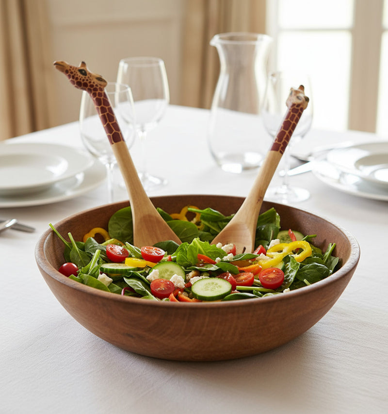 Wooden spoon and fork with giraffe pattern handles in tossed salad on a dining room table