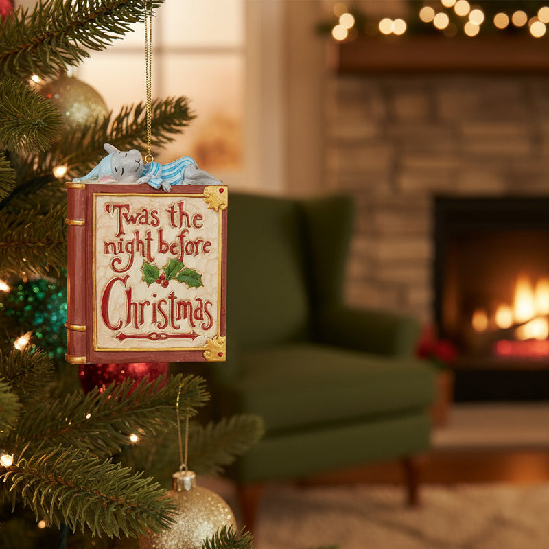 Jim Shore Heartwood Creek ornament shaped like a book with mouse on top 'Twas the night before Christmas' in Christmas tree with fireplace in background.