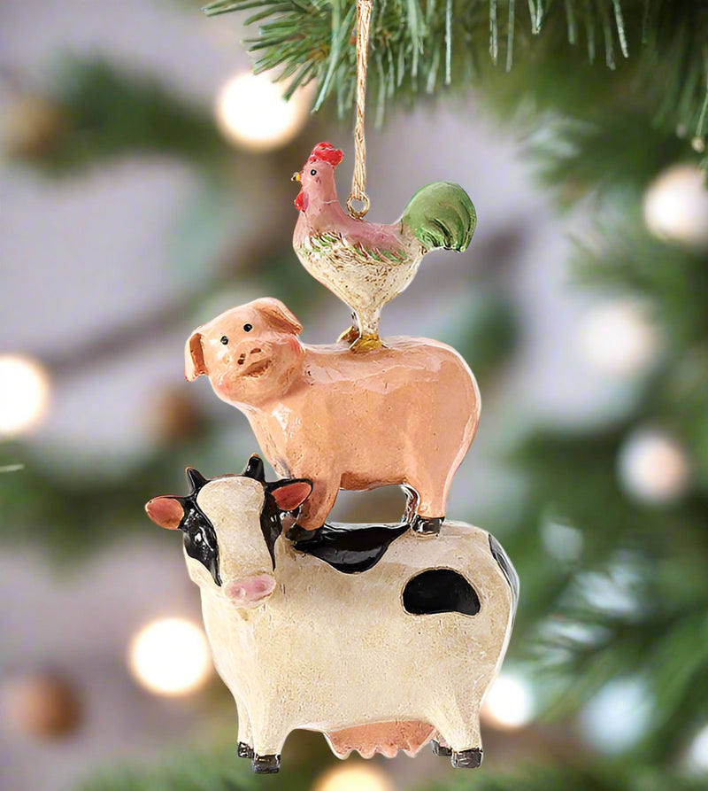 Decorative ornament with a cow, pig, and rooster on a Christmas tree.