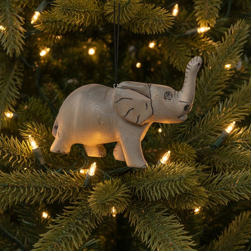 Hanging wooden elephant ornament in Christmas tree with lights