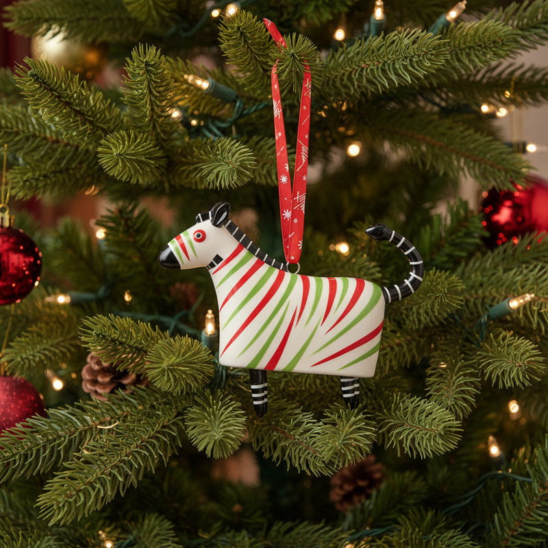 Zebra-shaped ornament with red and green stripes hanging in Christmas tree
