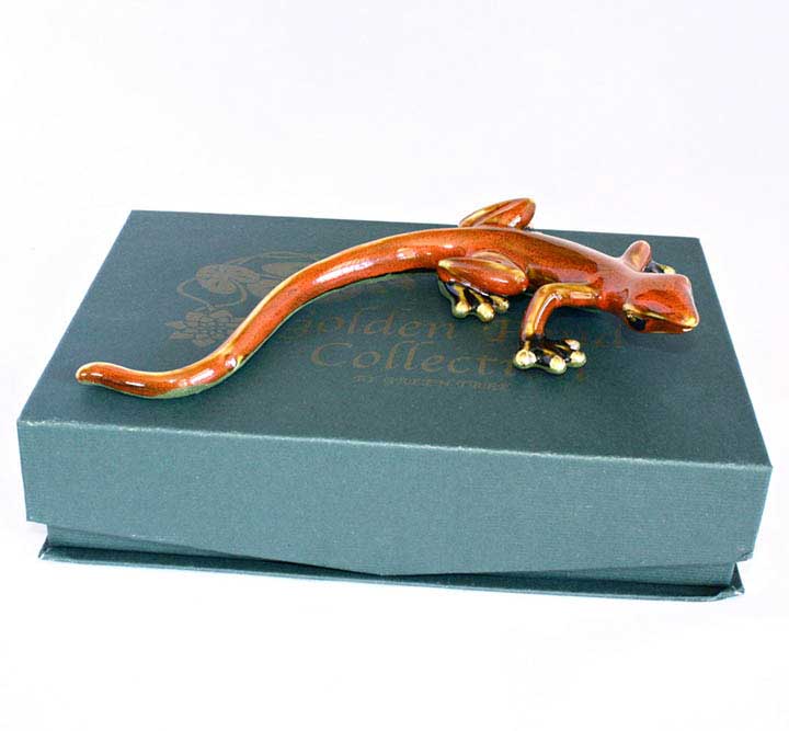 Golden Pond large red ceramic gecko figurine with gold feet - right side view of lizard on top of green gift box