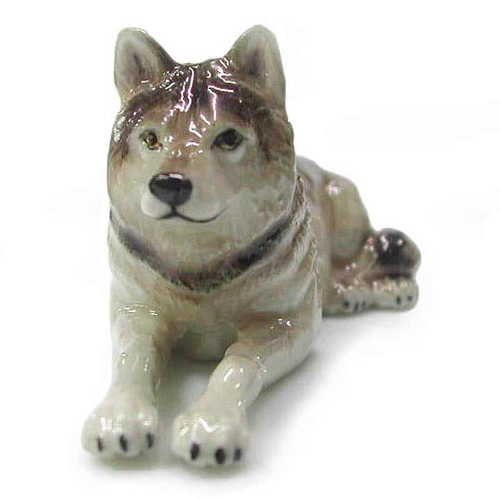 minature gray wolf lying down facing forward porcelain animal figurine