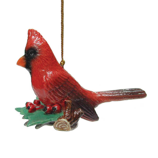porcelain red cardinal bird on branch with holly berrys ornament hanging from gold colored cord left side view