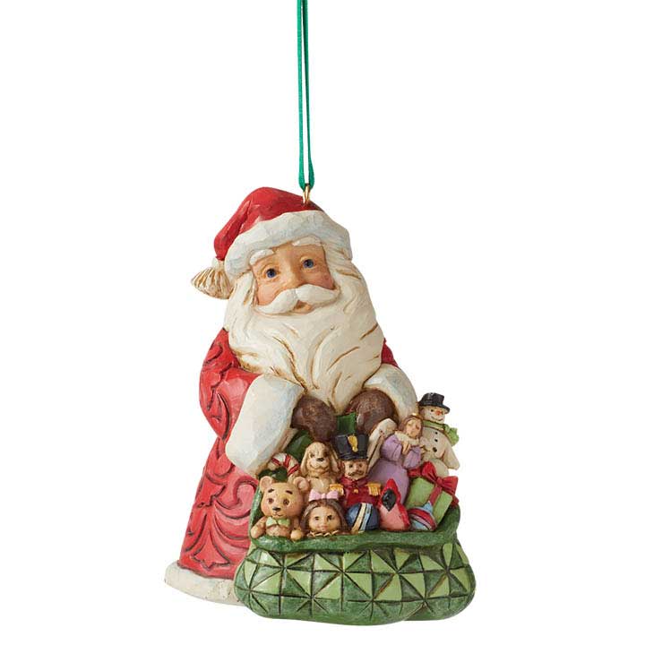 Jim Shore Worldwide Event Santa Ornament - front view, smiling santa holding a patterned green bag of assorted toys