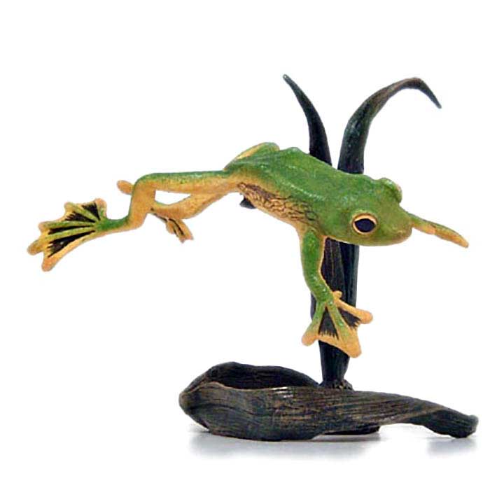 right side view of country artists brand figurine of green and yellow wallace's flying frog jumping above ground next to water reeds
