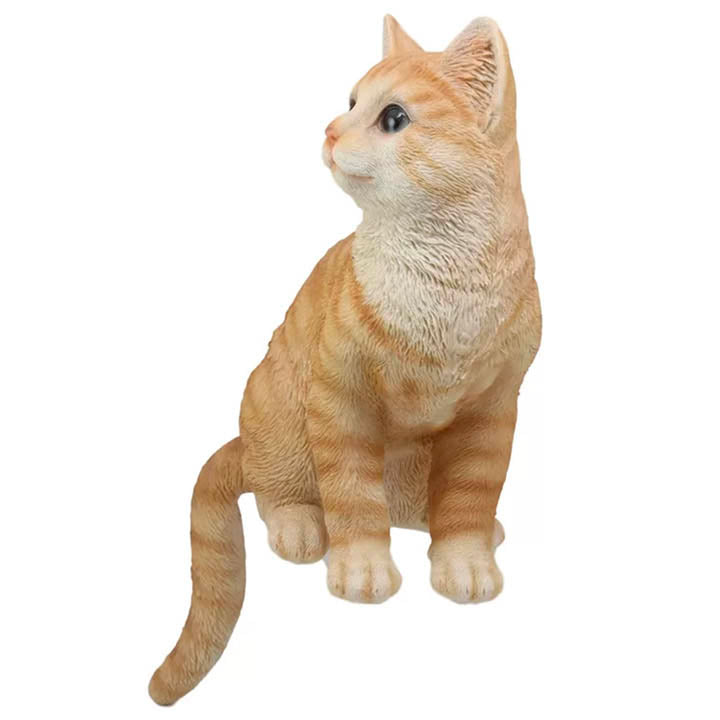 front view of orange tabby cat with green eyes looking left shelf sitter figurine