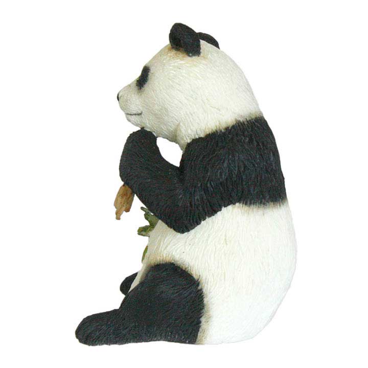 left side view of country artists brand minature figurine of sitting giant panda holding bamboo branches in both paws