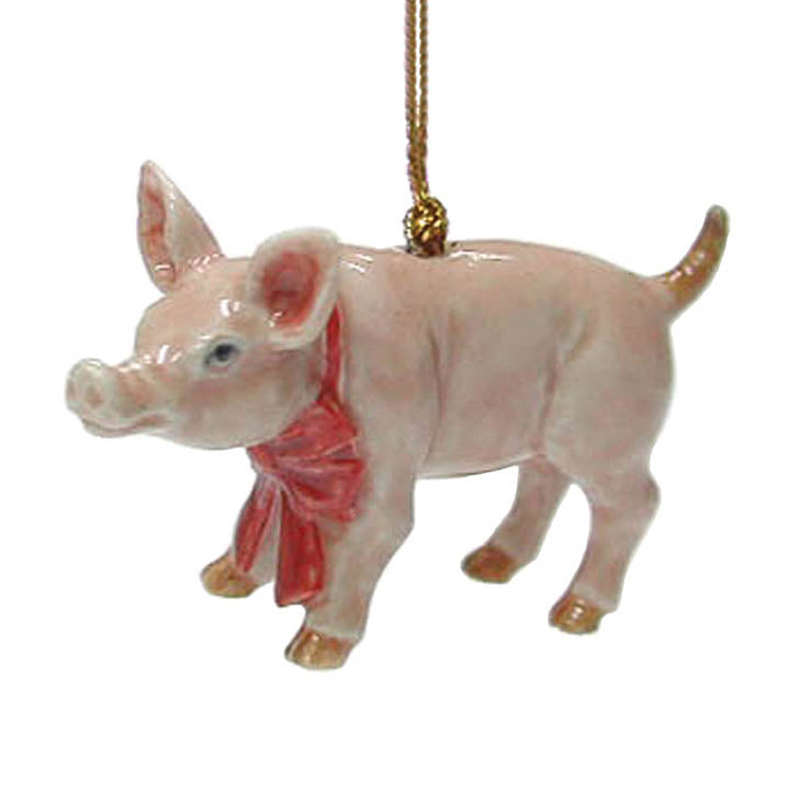 miniature porcelain pink pig wearing a red bow around its neck facing left christmas ornament left side view handing from gold colored cord