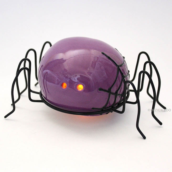 small purple spider halloween figurine with black metal legs front right side view showing orange LED eyes