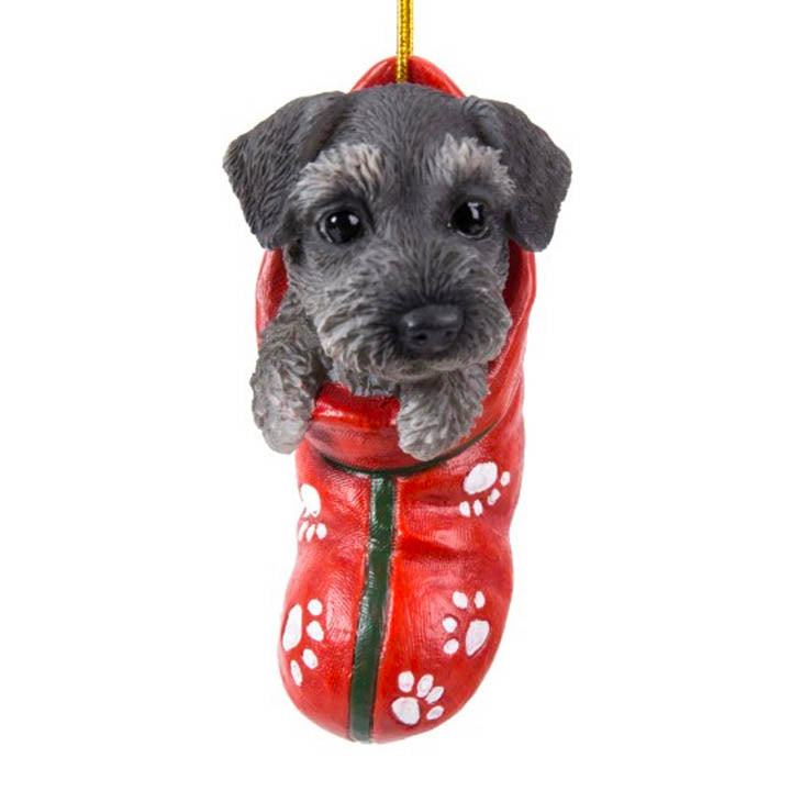 close up view of schnauzer puppy in red stocking with white paw print designs christmas ornament