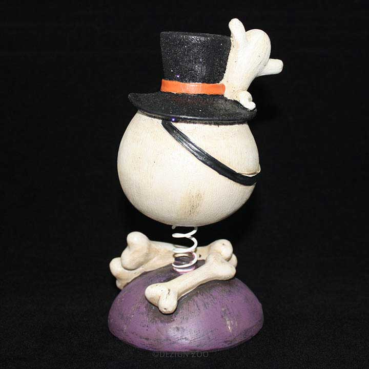 halloween skull in top hat with ghost bobble head figurine back view with black background showing bones below head