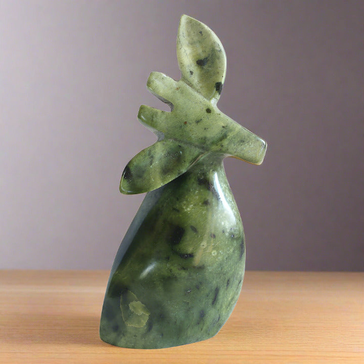 animal figurine, abstract carved black speckled green leopard stone sculpture of giraffe sitting on a shelf