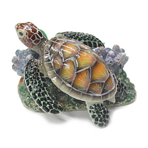 miniature porcelain sea turtle with orange yellow shell on green and gray coral figurine facing up left with top of back view